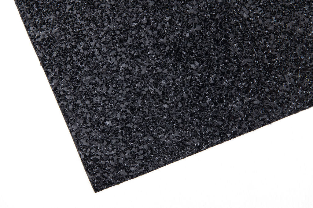 A close-up view of a black glittery wallpaper with a textured surface.